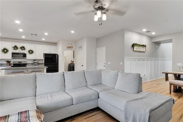 living room with ceiling fan and light wood-type flooring