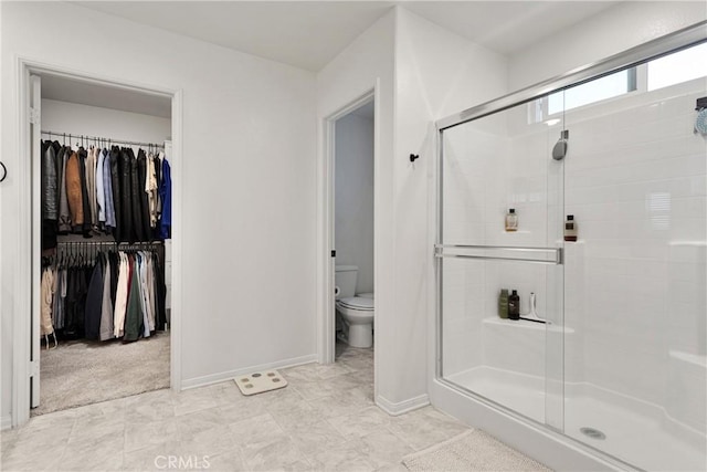 bathroom with toilet and a shower with shower door