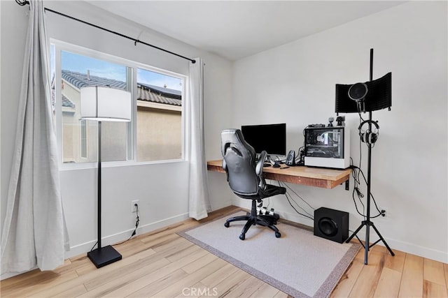 home office with light hardwood / wood-style flooring