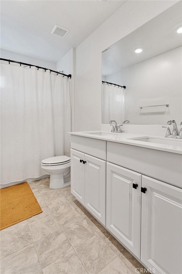 bathroom featuring toilet and vanity