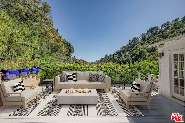 deck with an outdoor living space with a fire pit