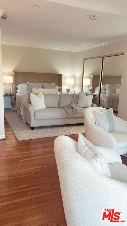 bedroom featuring hardwood / wood-style flooring, a closet, and crown molding