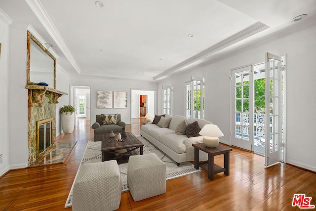 living room with a fireplace, ornamental molding, and hardwood / wood-style floors