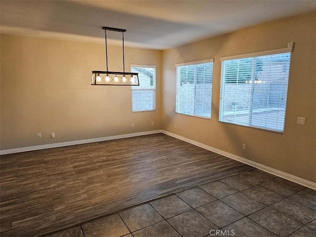 unfurnished dining area with dark tile patterned flooring