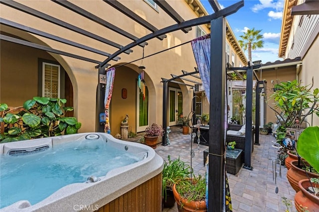 view of patio with a hot tub and a pergola