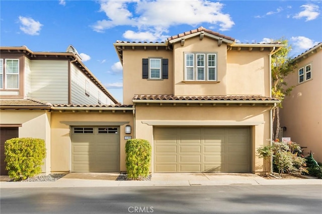 view of front of home featuring driveway, an attached garage, a tile roof, and stucco siding