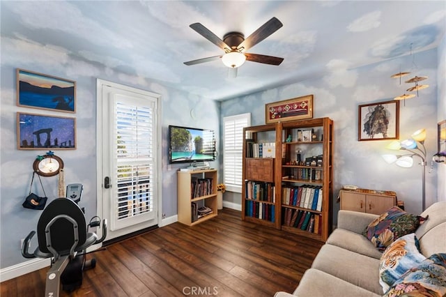 interior space featuring dark wood-style floors, a ceiling fan, and baseboards