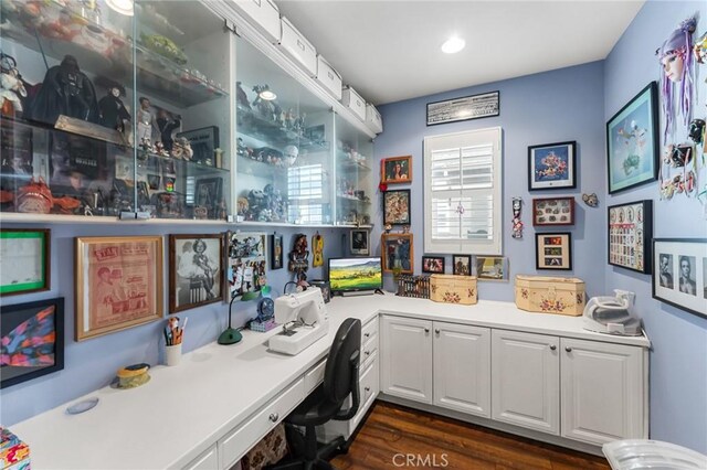 bar featuring dark hardwood / wood-style flooring, built in desk, and white cabinets