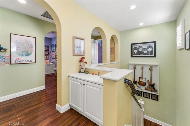 bar featuring dark hardwood / wood-style flooring and white cabinetry