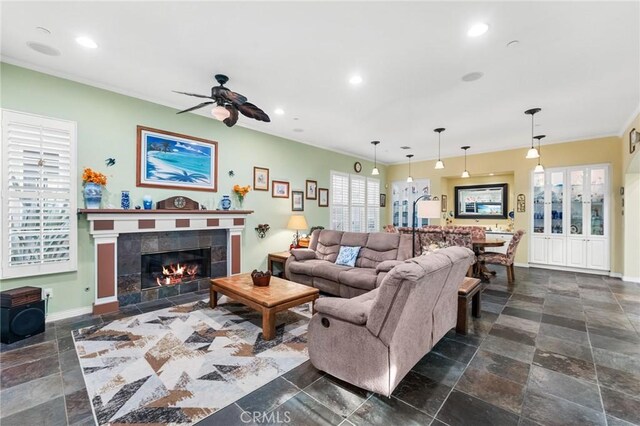 living room featuring a tile fireplace and ceiling fan