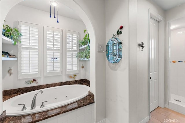 full bathroom featuring a closet, tile patterned flooring, a shower stall, and a jetted tub