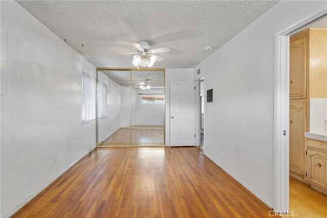 empty room featuring ceiling fan, a textured ceiling, and hardwood / wood-style floors