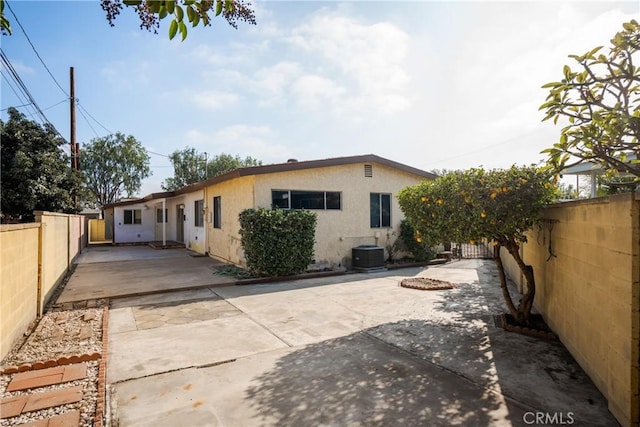 back of property featuring central AC unit and a patio