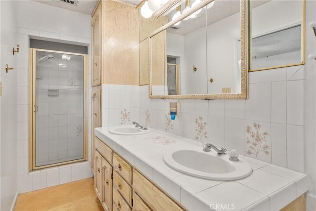 bathroom with vanity, tile walls, tile patterned floors, and walk in shower