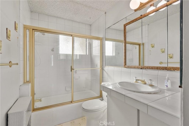 full bathroom with decorative backsplash, shower / bath combination with glass door, vanity, and toilet