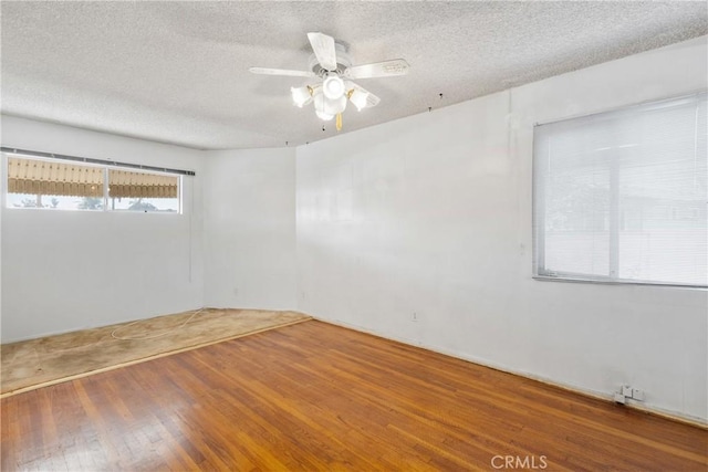 spare room with ceiling fan, wood-type flooring, and a textured ceiling