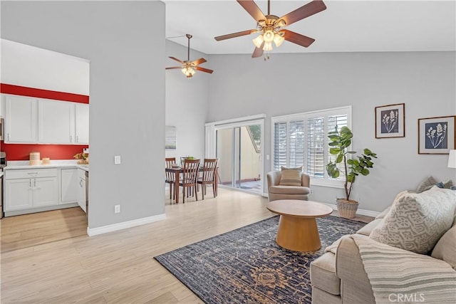 living room featuring ceiling fan, vaulted ceiling, and light hardwood / wood-style floors