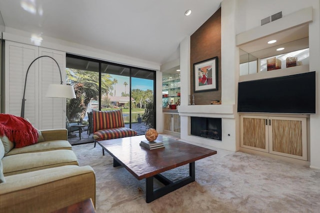 living room with vaulted ceiling, a large fireplace, and carpet flooring