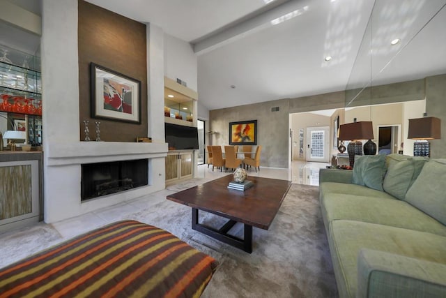 living room featuring vaulted ceiling with beams and a fireplace