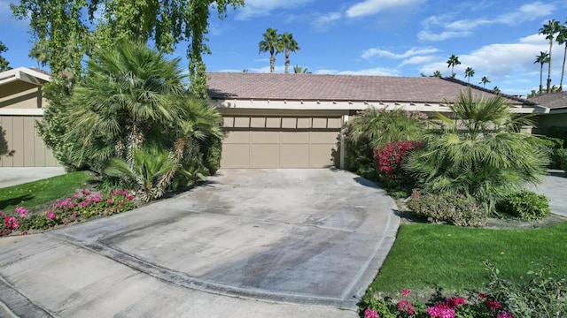 single story home featuring a garage and a front lawn