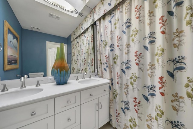 bathroom featuring toilet, vanity, and curtained shower