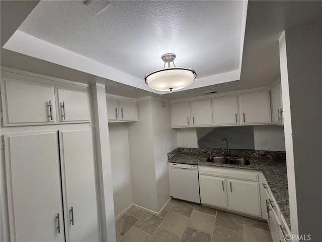 kitchen featuring dishwasher, sink, dark stone countertops, and white cabinetry