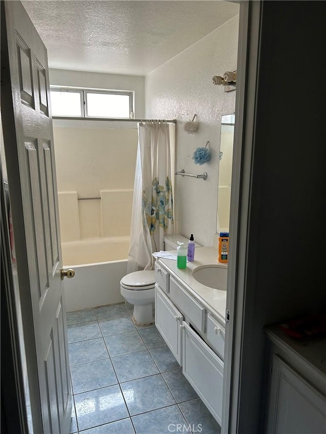 full bathroom with toilet, tile patterned flooring, shower / bathtub combination with curtain, a textured ceiling, and vanity