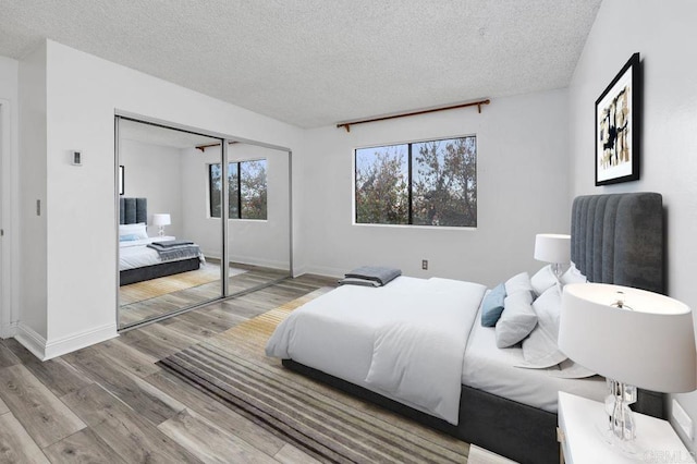 bedroom featuring a textured ceiling, a closet, and light wood-type flooring