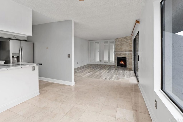 unfurnished living room featuring a textured ceiling and a fireplace