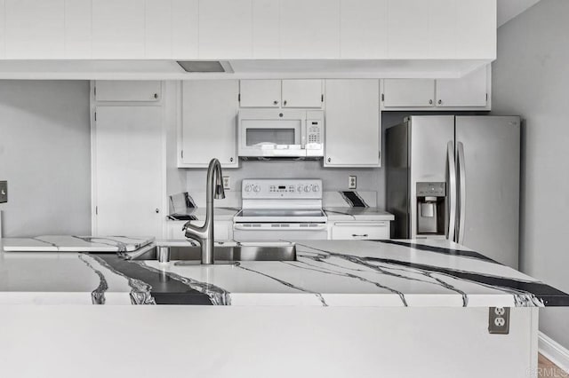 kitchen with sink, white appliances, and white cabinets