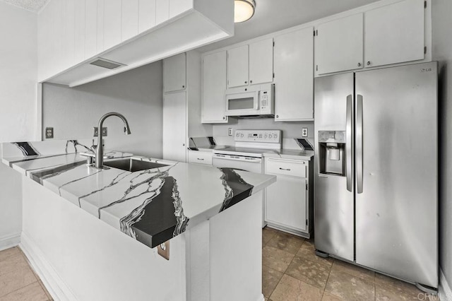 kitchen with sink, white appliances, white cabinets, and kitchen peninsula