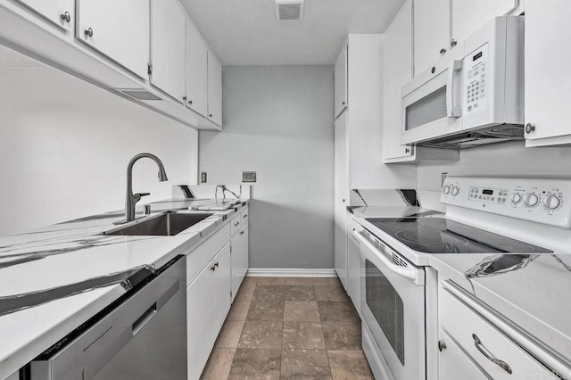 kitchen featuring baseboards, white appliances, visible vents, a sink, and light countertops