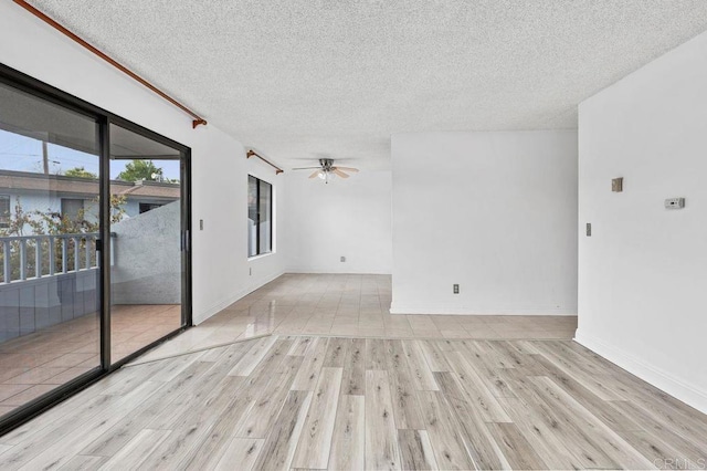 unfurnished room featuring light wood finished floors, a textured ceiling, baseboards, and a ceiling fan