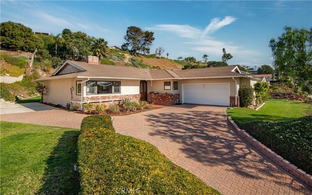 ranch-style house featuring a garage and a front lawn