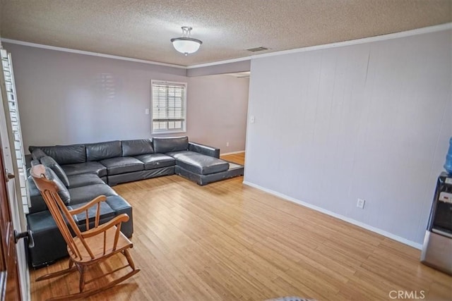 living room featuring a textured ceiling, ornamental molding, and hardwood / wood-style flooring