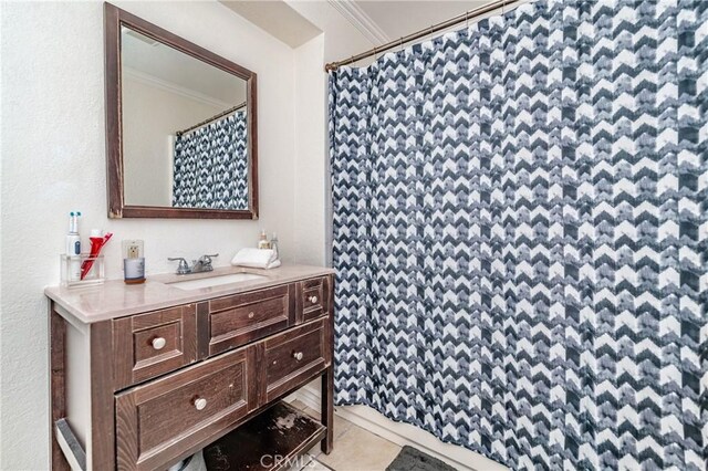 bathroom featuring a shower with shower curtain, ornamental molding, tile patterned flooring, and vanity