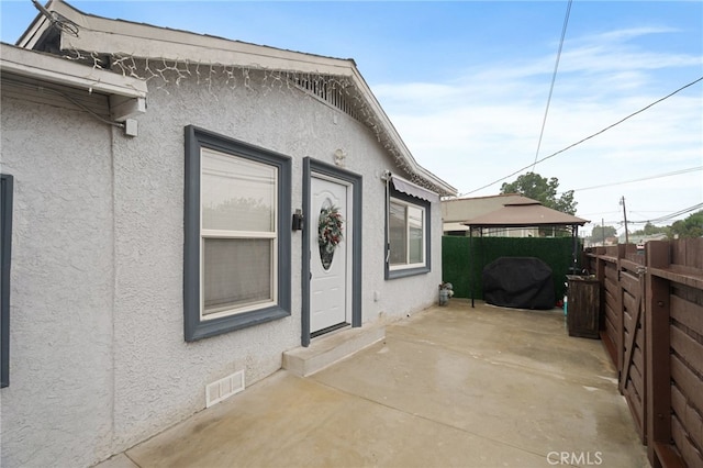 view of side of home featuring a gazebo and a patio area