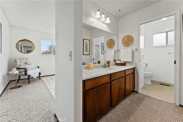 bathroom featuring a textured ceiling, toilet, and vanity