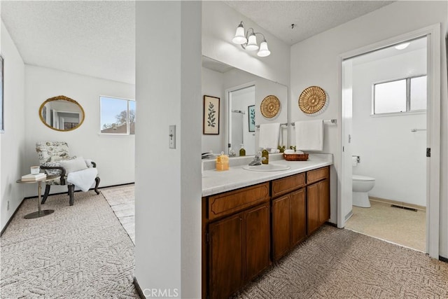 bathroom with vanity, toilet, and a textured ceiling