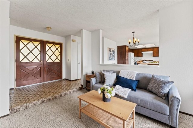 living room with a textured ceiling and an inviting chandelier