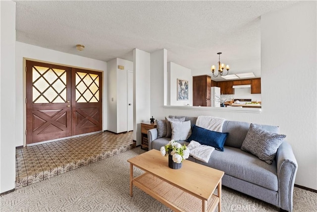 living room with a textured ceiling, light colored carpet, and a notable chandelier