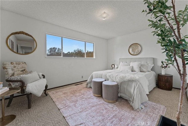 bedroom with a textured ceiling and light colored carpet