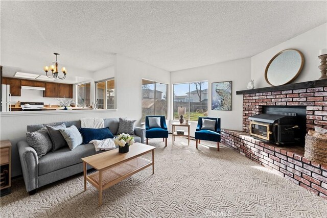 living room with a wood stove, a textured ceiling, and a chandelier