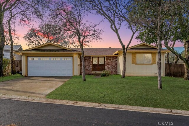 ranch-style house with a garage and a yard