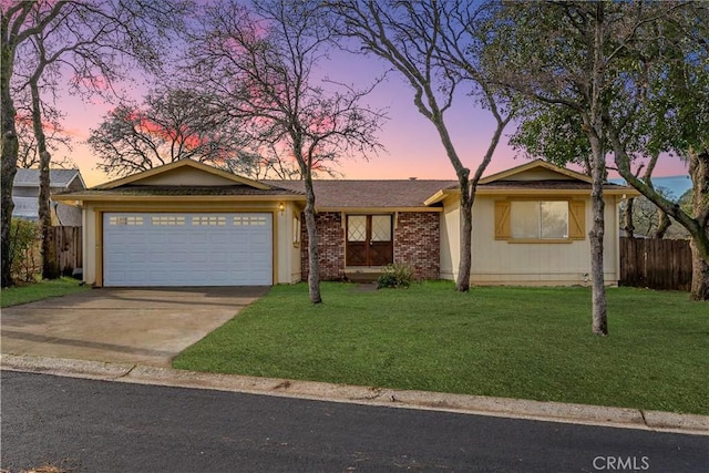 single story home featuring a garage and a yard