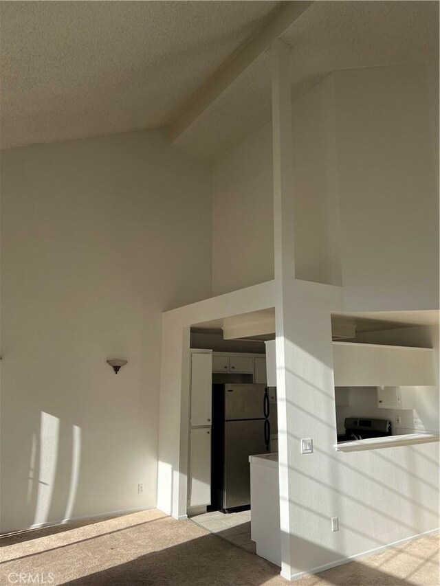 interior space featuring light carpet, a textured ceiling, and lofted ceiling