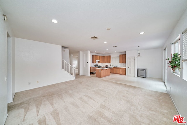 unfurnished living room featuring light colored carpet