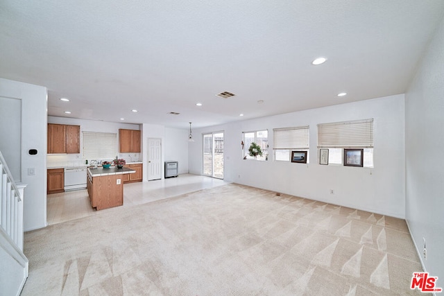 unfurnished living room with light colored carpet