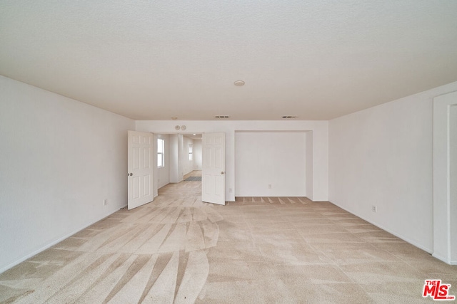 carpeted empty room featuring a textured ceiling