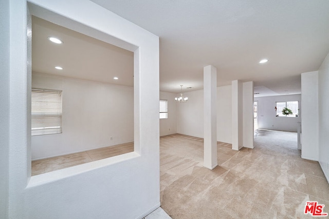 basement with light carpet and a notable chandelier